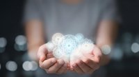 Hands holding glowing digital brain with circuit patterns representing artificial intelligence, machine learning and neural network technology concepts.