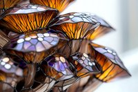 Glowing orange and purple stained glass mushrooms in decorative arrangement, featuring intricate mosaic patterns and metallic stems, creating magical forest ambiance.