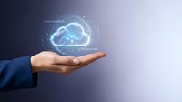 Businessman in suit holding glowing holographic cloud with digital network interface, representing cloud computing innovation and technology solutions.