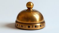 Vintage brass service bell with decorative perforated base and round finial top on white background, isolated antique hotel or restaurant counter bell.