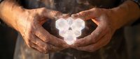 Male hands holding glowing crystal or mineral stone in heart shape, symbolizing healing, wellness, spirituality and alternative medicine practices for wellness concepts.