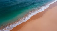 Aerial view of turquoise ocean waves meeting pristine sandy beach with white foam creating natural diagonal composition, minimalist seascape for wall art and design projects.