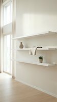 Minimalist white floating shelves with ceramic vase and small plant in bright modern interior with natural light from large windows for home decor inspiration.