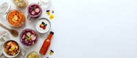 Gourmet appetizers and cocktails arranged on white marble surface with wine bottle, olives, berries and elegant glassware for entertaining and dining.