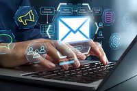 Digital email marketing concept with businessman hands typing on laptop keyboard surrounded by glowing communication icons and data symbols.