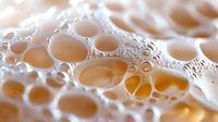 Macro close-up of honeycomb structure with golden honey cells and crystalline formations, showcasing natural beekeeping and apiary production details.
