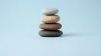 Zen balanced stone stack on soft blue background for meditation wellness spa therapy mindfulness relaxation balance harmony spiritual healing concepts.