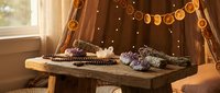 Cozy autumn reading nook with wooden table, open books, warm lighting and orange garland decoration creating peaceful study atmosphere for relaxation.