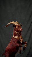 Majestic goat with ornate golden baroque decorative elements and curved horns against dark textured background for luxury branding and artistic projects.