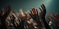 Crowd of people raising hands up at concert or event with dramatic lighting and atmospheric mood for entertainment and music industry.