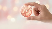 Hand holding glowing target icon with arrow symbolizing goal achievement and business success strategy on soft bokeh background.
