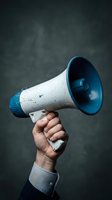 Hand holding vintage white and blue megaphone against dark textured background for communication and announcement concepts.