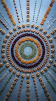 Mandala pattern made from mixed nuts seeds and dried fruits arranged in concentric circles and radiating lines on blue background for healthy eating concepts.