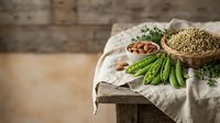 Fresh green peas in pods with lentils and herbs on rustic wooden table. Healthy organic legumes and vegetables for cooking and nutrition concepts.