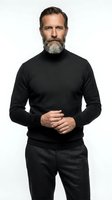 Middle-aged Caucasian man with full beard wearing black turtleneck sweater and charcoal trousers, standing against white background for portrait and corporate use.