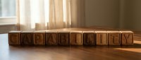 Wooden alphabet blocks spelling CAPABILITY arranged in a row on a table, warm sunlight from window, concept of skill and potential.