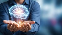 Businessman holding glowing digital brain hologram with neural networks and connections representing artificial intelligence and innovation.