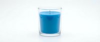 Blue scented candle in clear glass holder isolated on white background for home decor, relaxation and aromatherapy concepts.