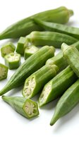 Fresh green okra pods whole and sliced showing seeds inside on white background isolated for cooking recipes and healthy eating concepts.