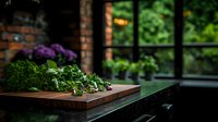 Fresh green herbs and vegetables on wooden cutting board in rustic kitchen interior with window view to garden, moody natural lighting creates cozy atmosphere.