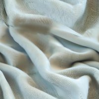 Soft white fabric with gentle folds and creases creating subtle shadows and texture, suitable for backgrounds and textile design projects.