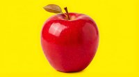 Glossy red apple with leaf isolated on bright yellow background, ready for design use on packaging, marketing materials, and educational content.