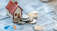 Small wooden house model with coins on financial documents representing real estate investment and property market analysis for mortgage planning.