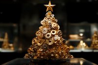 Steampunk Christmas tree made from brass gears, cogs and mechanical parts topped with golden star against dark background. Creative holiday decoration.