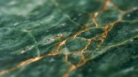 Green marble stone surface with golden veins and natural texture patterns for luxury interior design and architectural applications.