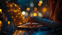 Female hands typing on laptop keyboard at night with magical glowing screen and bokeh lights creating atmospheric digital workspace environment.