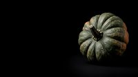 Textured green and orange pumpkin isolated on dark background, suitable for autumn harvest designs, fall decorations, and seasonal marketing materials.