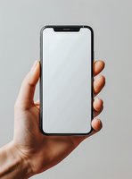 Hand holding modern smartphone with blank white screen against light gray background, mockup ready for app or website presentation.