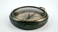 Vintage brass compass with aged patina on white background, antique navigation instrument for maritime and adventure themes.