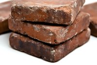 Stack of dark chocolate bars with cocoa powder coating shown in close-up macro photography on white background, displaying rich texture and layers of gourmet confection.