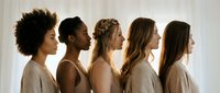 Diverse group of five women standing in profile showing different ethnicities and hairstyles representing unity, sisterhood and female empowerment in natural light.