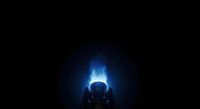 Silhouette of person sitting in front of glowing blue light source, creating dramatic backlighting effect suitable for technology, science fiction, and creative design projects.