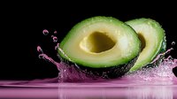 Fresh avocado halves with pink water splash on black background, dynamic food photography composition with liquid motion effect and reflection.