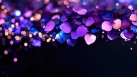 Glowing heart shaped bokeh lights in purple and blue colors creating romantic atmosphere against dark background, soft focus magical effect.