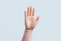 Female hand raised in greeting gesture wearing pink sweater sleeve against light blue background. Clean minimal composition for social media and blogs.