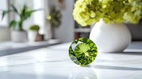 Round cut peridot gemstone on white surface with soft natural lighting and floral decoration in background, showcasing luxury jewelry element with brilliant facets.