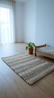 Minimalist bright room with woven rug on light wood floor, potted monstera plant, wooden bench, and sheer curtains by window.