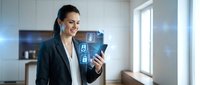 Businesswoman with dark hair and olive complexion wearing professional navy blazer and white shirt holds tablet displaying digital security icons in modern office environment with natural light.
