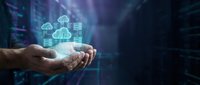 Hands holding glowing cloud computing icons with digital network connections in server room environment for technology and data storage concepts.