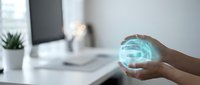 Hands holding glowing blue digital sphere with data streams in modern office workspace representing technology innovation and futuristic business solutions.