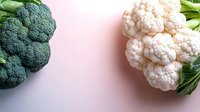 Fresh broccoli and cauliflower vegetables on pink background for healthy cooking and nutrition concepts.