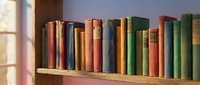 Row of antique leather-bound books with colorful spines arranged on wooden shelf near window, suitable for library, education, and literature design projects.