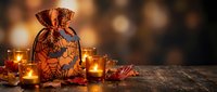 Festive Halloween treat bag with spooky pumpkin design surrounded by glowing candles on rustic wooden table creating warm atmospheric holiday decoration scene.