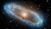 Majestic spiral galaxy with glowing blue edges and golden center illuminated against dark space background, surrounded by distant stars and cosmic dust.