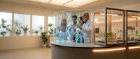 Diverse medical research team of doctors and scientists working together in modern laboratory examining test samples and discussing findings.