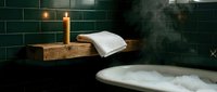 Wooden bathtub caddy with burning candles and folded towel beside soaking tub with bubbles and green tile wall for spa, relaxation, and wellness design projects.